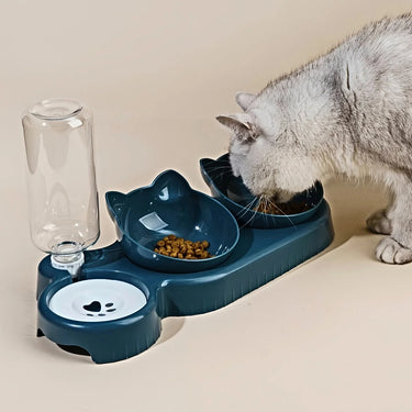 A gray cat eats from the KittyNook Cat Co. Cute 3 In 1 Cats Bowls With Water Feeder shaped like a cat’s head.